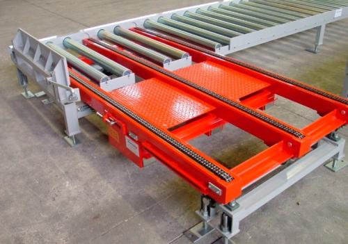 Red pallet-transfer section connecting heavy-duty roller conveyors
