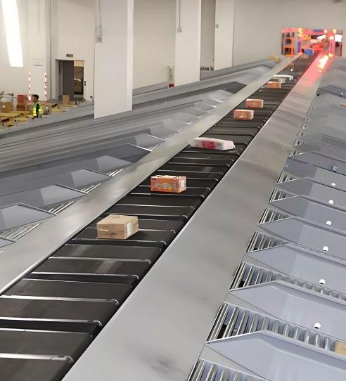 Packages traveling along a sorter conveyor beside angled discharge chutes